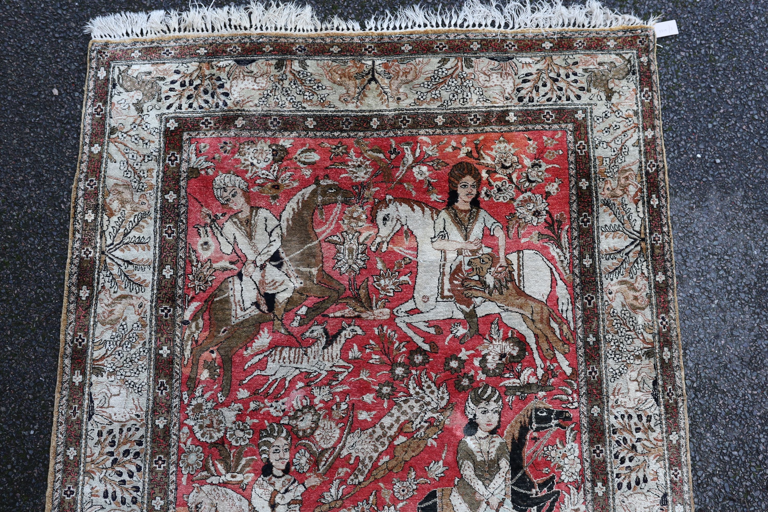 An early 20th century Tabriz pictorial red ground rug, woven with hunters on horseback, 208 x 135cm.
